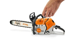 Zabawka pilarka Stihl w ręce osoby.