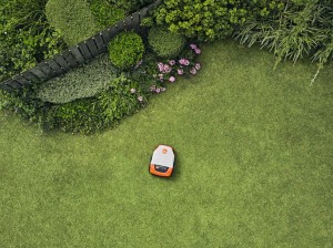 Kosiarka automatyczna Stihl iMOW 6 pracująca na trawniku w ogrodzie.
