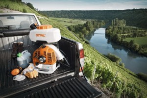 Stihl SR 430 Opryskiwacz 14l na tle krajobrazu z rzeką i winnicą.