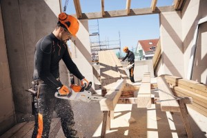 Mężczyzna pracujący pilarką akumulatorową Stihl MSA 160 C-B na placu budowy.