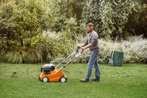 Mężczyzna używający Stihl RL 540 Wertykulator spalinowy w ogrodzie.
