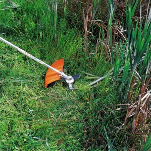Stihl BrushCut 350-3, Trójząb, nóż do wycinania zarośli w akcji na trawie.