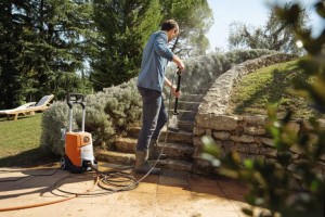 Mężczyzna czyszczący schody myjką wysokociśnieniową Stihl RE 110.