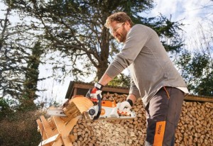 Mężczyzna tnie drewno pilarką Stihl MSA 70 C-B.