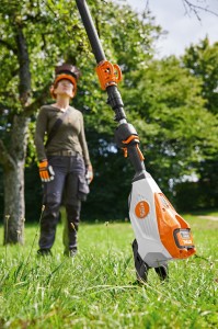 Podstawka do HTA 135 / HLA 135 Stihl na tle drzewa.