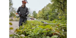 Mężczyzna przycina żywopłot urządzeniem Stihl KMA 135 R KombiMotor.
