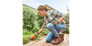 Kobieta przycinająca żywopłot za pomocą Stihl HSA 26 Akumulatorowe nożyce do żywopłotów.