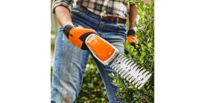 Stihl HSA 26 Akumulatorowe nożyce do żywopłotów w użyciu, ręka w rękawicach ogrodniczych.