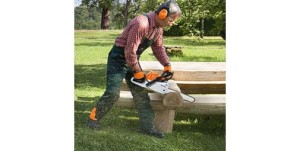 Mężczyzna używający Stihl MS 231 C-BE Pilarki spalinowej do cięcia drewna.