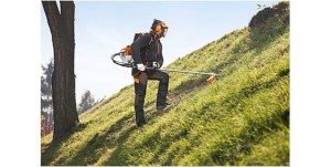 Mężczyzna koszący trawę na zboczu przy użyciu Stihl FR 410 C-E Plecakowa kosa spalinowa.