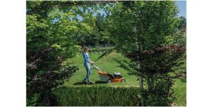 Kobieta kosząca trawę kosiarką Stihl RM 650 VS Kosiarka z hamulcem noża w ogrodzie.