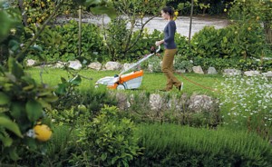 Kobieta kosząca trawnik kosiarką Stihl RME 235.