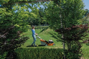 Kobieta kosi trawnik kosiarką Stihl RM 650 VS z hamulcem noża.