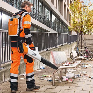 Mężczyzna używający Stihl BGA 100 Dmuchawa akumulatorowa do sprzątania ulicy.