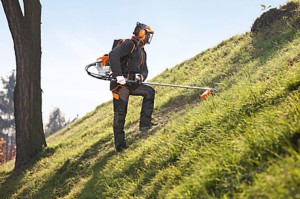 Mężczyzna używający Stihl FR 410 C-E plecakowej kosy spalinowej na zboczu.