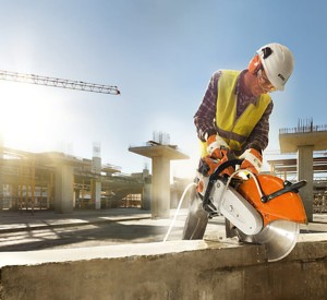 Robotnik używający Stihl TS 500i Przecinarka o mocy 3,9 kW / 5,3 KM do cięcia betonu na budowie.