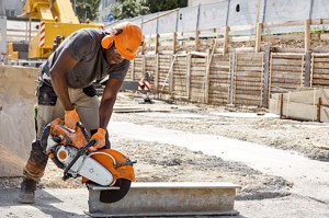Pracownik budowlany używający Stihl TS 500i do cięcia betonu na placu budowy.