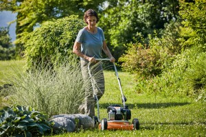Kobieta kosząca trawnik kosiarką Stihl RM 2 RC Kosiarka do mulczowania.