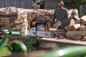 Stihl MS 271 Pilarka spalinowa przy stosie drewna.