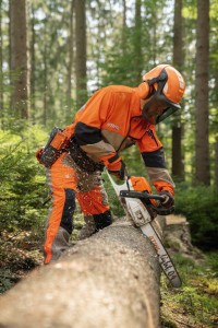 Mężczyzna pracujący pilarką Stihl MS 261 C-M w lesie.