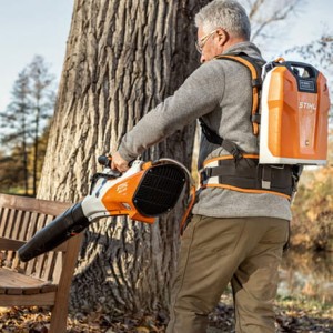 Mężczyzna używający Stihl BGA 200 dmuchawy akumulatorowej w parku.