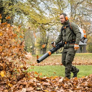 Mężczyzna używający Stihl BR 800 C-E Dmuchawa Plecakowa do zdmuchiwania liści w parku.