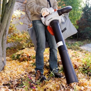 Mężczyzna używający Stihl SH 56 Odkurzacza spalinowego w ogrodzie.
