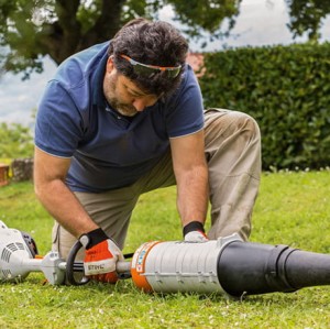 Mężczyzna używający Stihl KM 56 RC-E KombiMotor na trawie.